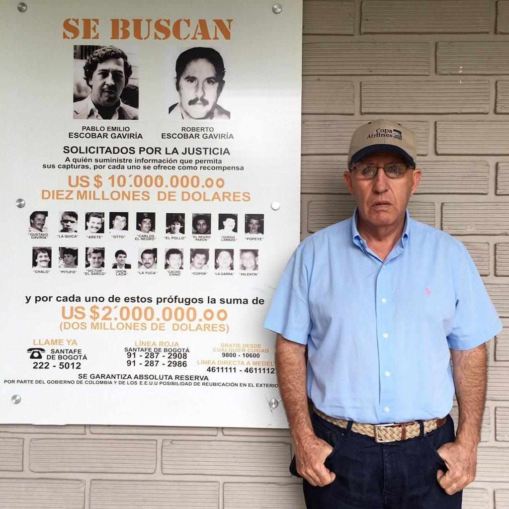 Roberto, fratello di Pablo, affianco ad un manifesto segnaletico che li riguarda