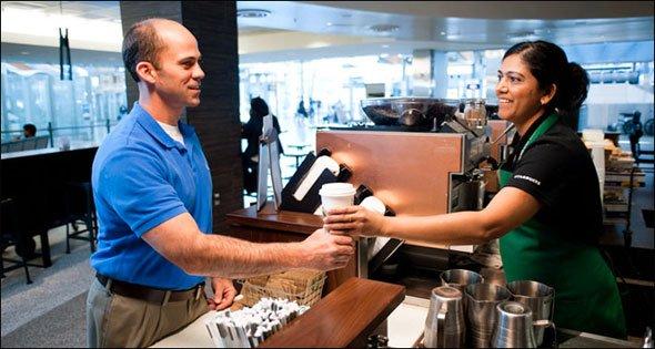 Un signore prende un caffè al banco di Starbucks