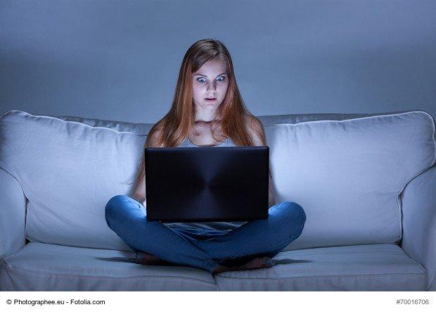 Image of shocked girl using facebook at night 
