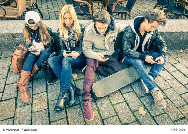 Group of young hipster friends playing with smartphone