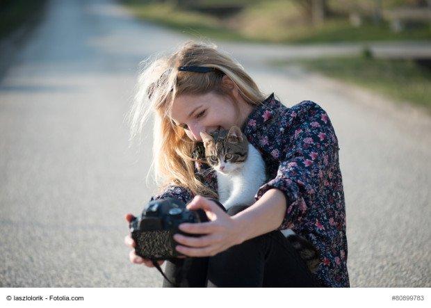 Cute blonde woman taking self portrait with a cat