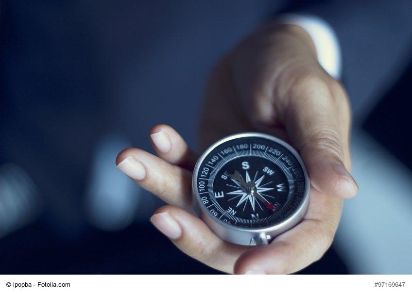 Businessman with a compass holding in hand, color tone film look