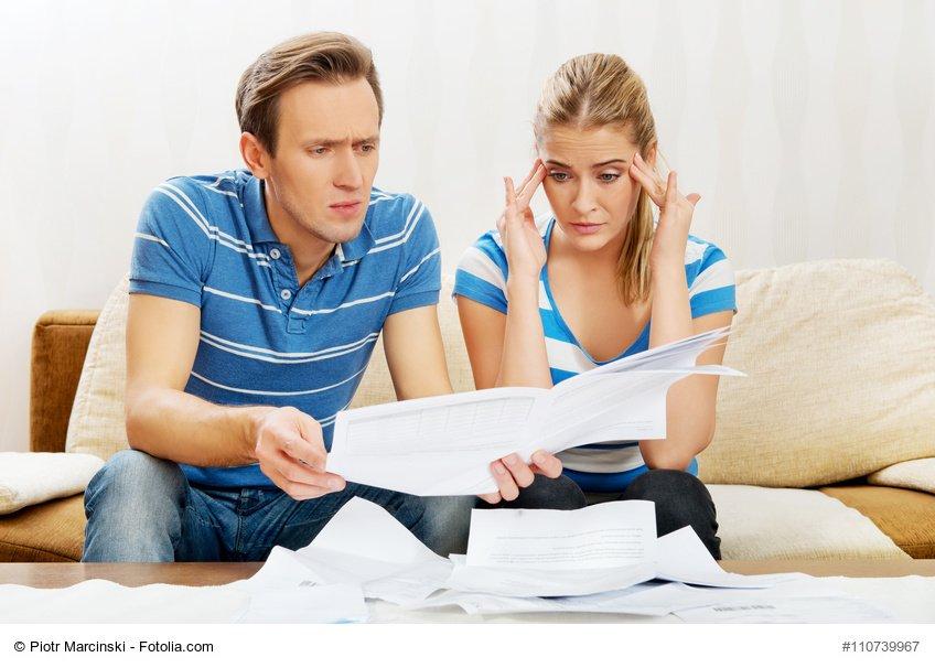 Worried couple after calculating bills sitting at home.