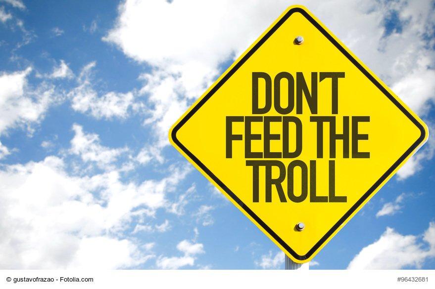 Don't Feed the Troll sign with sky background