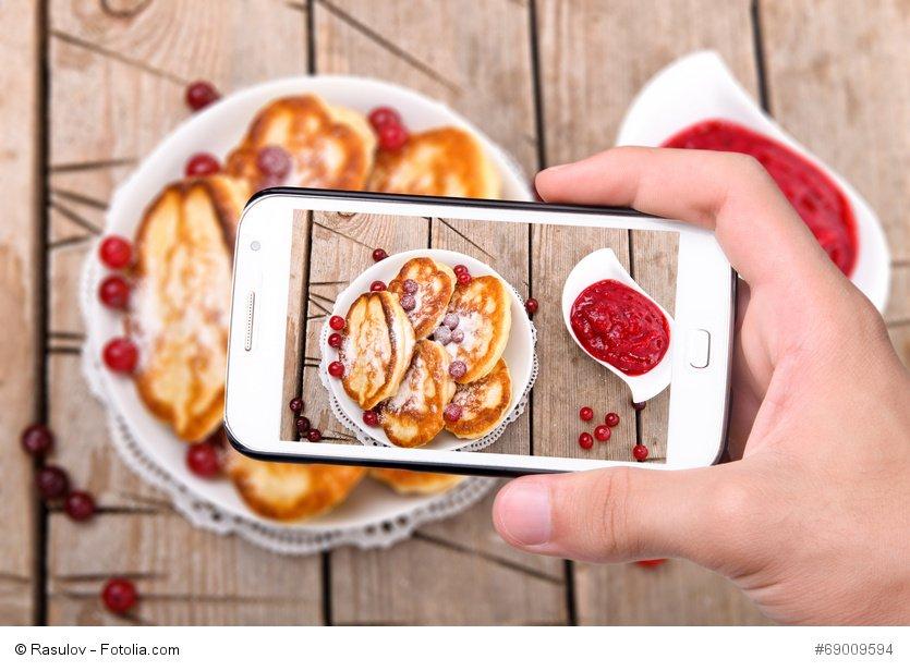 Hands taking photo pancakes with smartphone