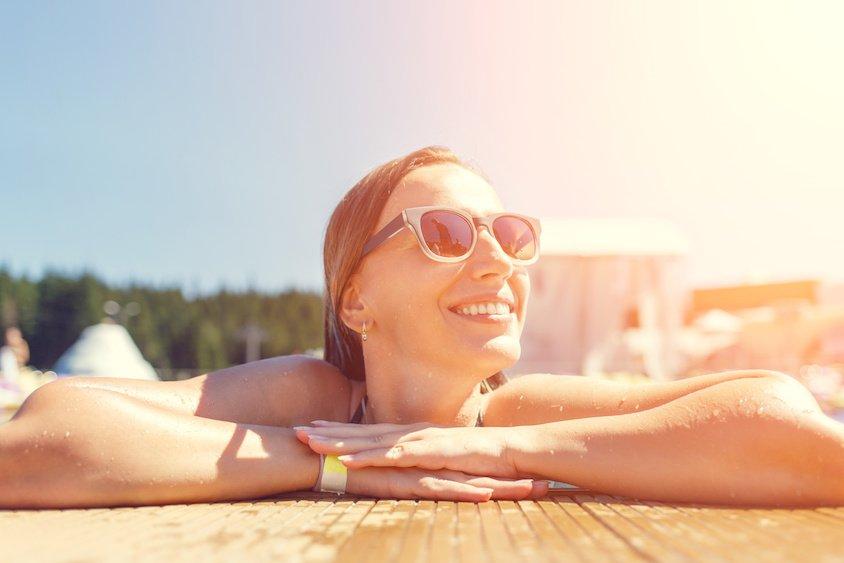 Young smiling woman in swimming pool on summer vacation