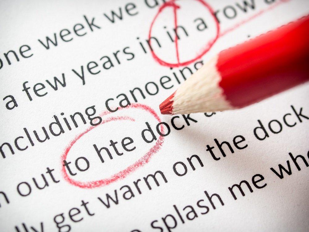 Proofreading red pencil with various errors on paper